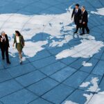Business Professionals Walking Across A World Map Floor Gettyimages 91496535 1200w 628h.jpg