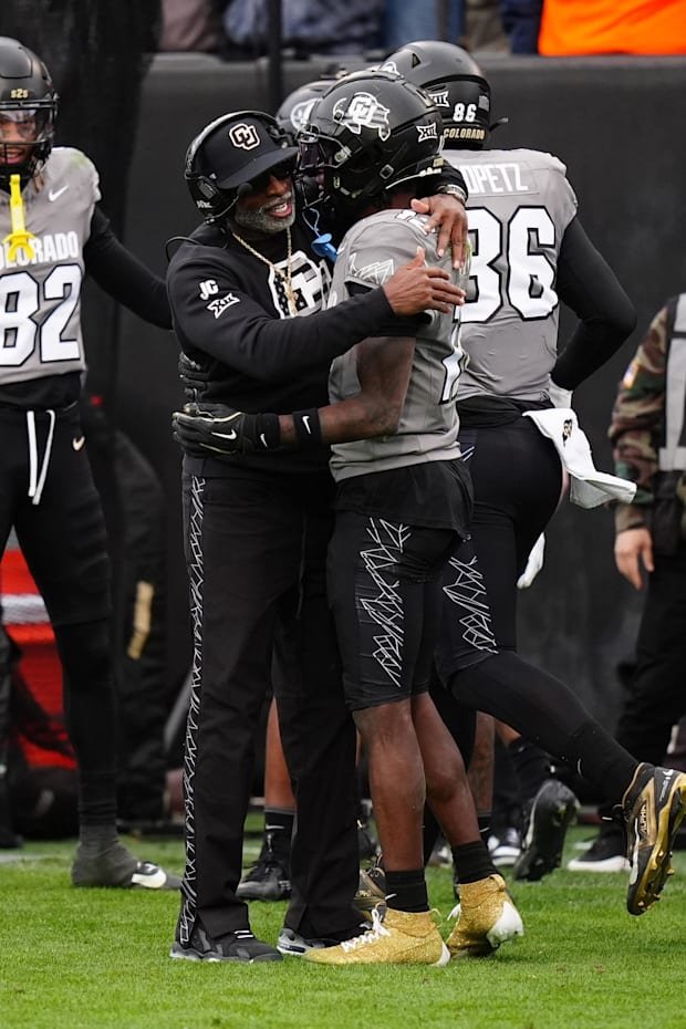 Nov 16, 2024; Boulder, Colorado, USA; Colorado Buffaloes head coach Deion Sanders hugs wide receiver Travis Hunter (12) follo