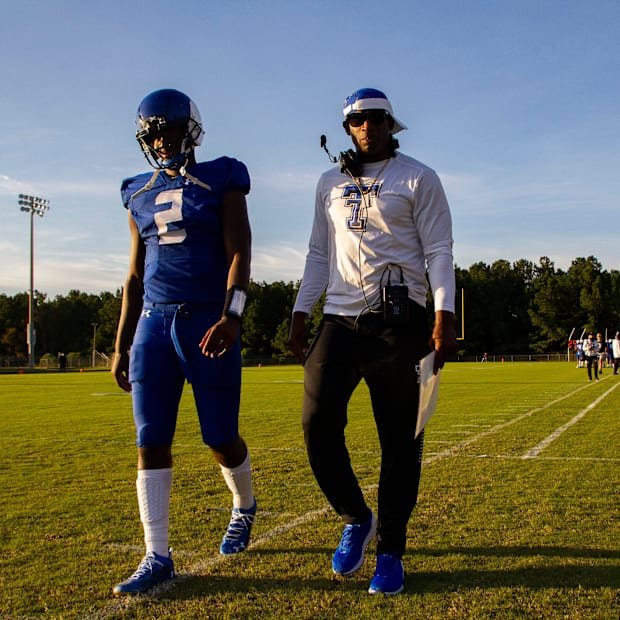 Trinity Christian School offensive coach Deion Sanders walks down the sideline as he talks to his son Shedeur Sanders (2), wh
