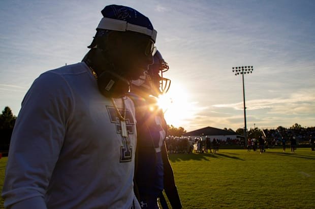 Trinity Christian School offensive coach Deion Sanders walks down the sideline as he talks to his son Shedeur Sanders (2), wh