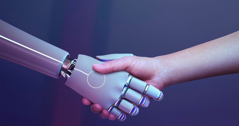 Robot hand + human hand over a laptop Why Small Business Trends Matter More